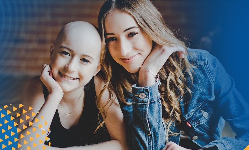 A girl on the left, with her chin resting on her right hand, smiling, and a woman on the right, leaning close to her and smiling